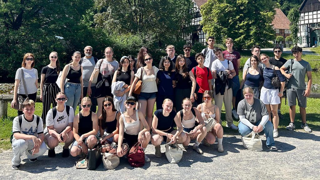 Deutsche und türkische Schüler:innen des Erasmus+-Austauschs posieren gemeinsam vor historischen Gebäuden im LWL-Freilichtmuseum Detmold. Der Austausch zwischen der Gesamtschule Rödinghausen und dem Kabataş Erkek Lisesi in Istanbul besteht seit 2022.