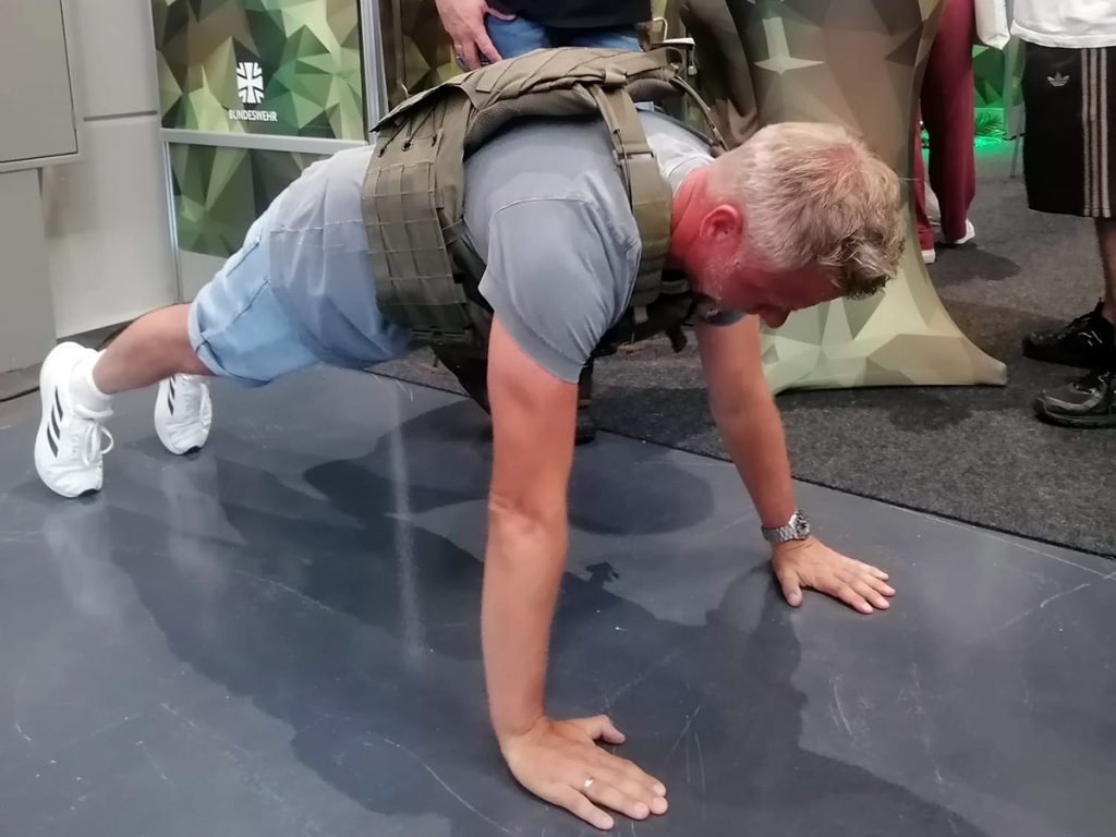 Ein Lehrer testet am Stand der Bundeswehr einen Liegestütz mit schwerem Rucksack. Auf der Vocatium konnten die Besucher:innen verschiedene Berufe und deren Anforderungen praktisch kennenlernen.