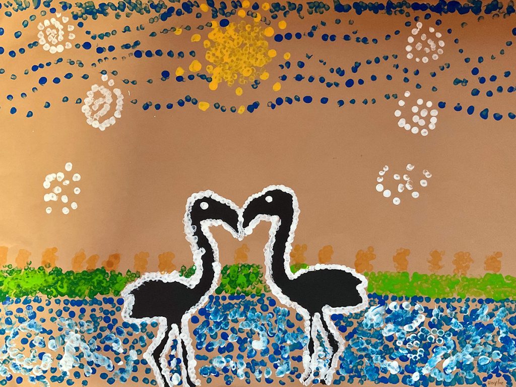 Zwei schwarze Flamingos stehen vor einer farbenfrohen Landschaft mit blauem Wasser, grüner Vegetation und gelber Sonne. Das Bild wurde in einer an die Kunst der australischen Aborigines angelehnten Punktmaltechnik gestaltet.